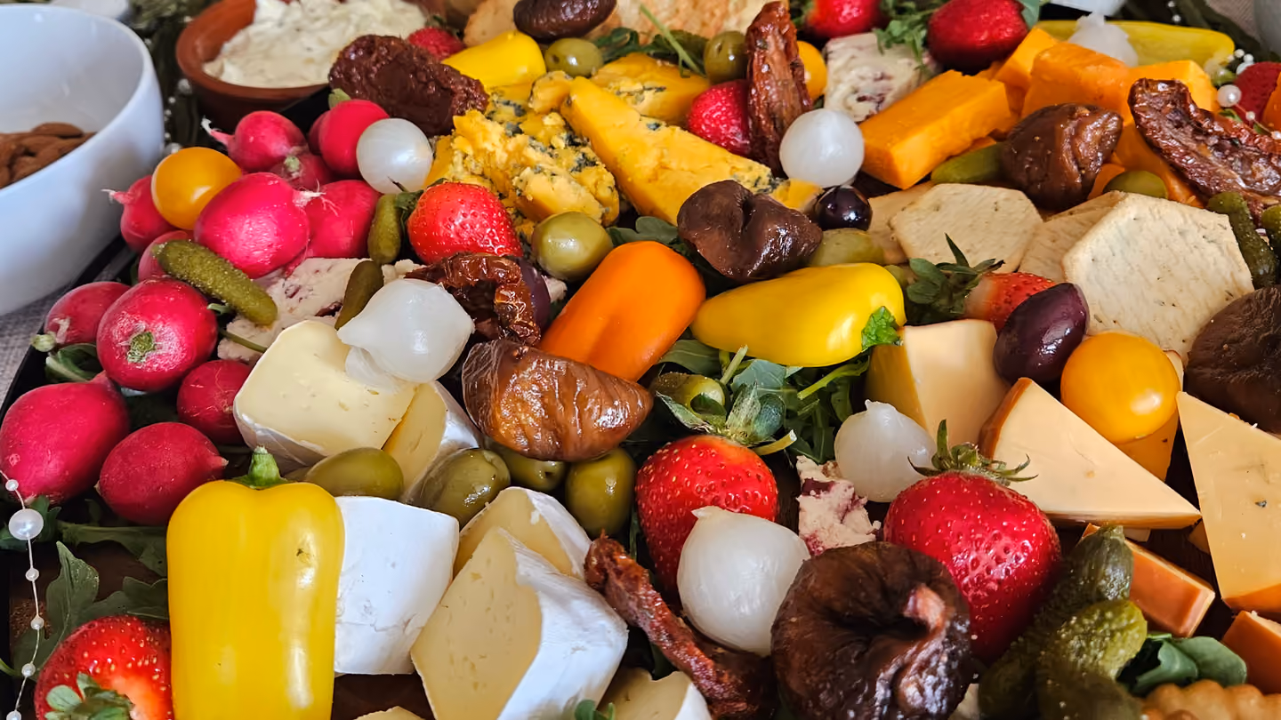 A grazing table with radishes, cheese and peppers
