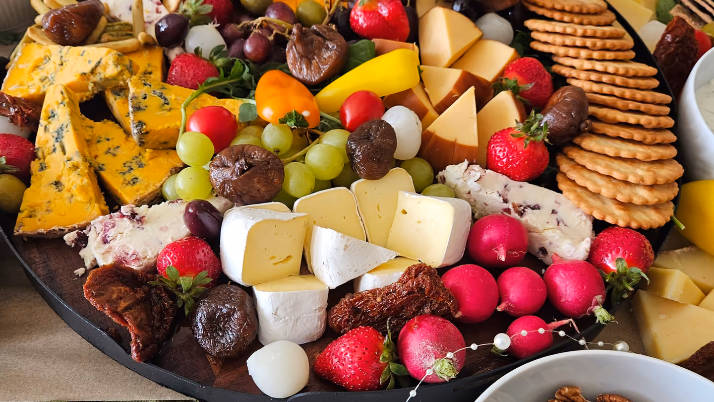 A grazing tray of cheeses, fruit and crackers